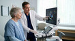 © Xenia - Senior woman observing echocardiogram results with doctor in clinic. Male cardiologist explaining heart valve health diagnosis on ultrasound screen. Cardiology and medical imaging concept