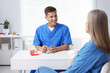 © New Africa - Doctor consulting woman regarding dental implantation at desk in clinic