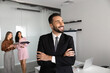 © fizkes - Portrait of Hispanic businessman, team leader standing with arms crossed, smiling, thinking on future business opportunities, career perspectives, corporate success during office meeting. Leadership