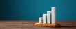 © Phanupong - Wooden block bar chart showing business growth on wooden surface against blue background with copy space for professional financial presentations