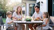 © Andrii Fanta - Family Saying Grace Before Outdoor Dinner on Backyard Patio, Golden Hour