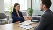 © InfinityVisuals - Job Interview Success: A confident female candidate shakes hands with a male interviewer in a modern office setting, sealing a successful job interview and a promising start to a new career.