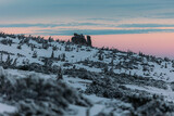  Snow covered landscape with stone formation Słonecznik  at sunset