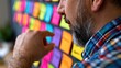 © spyrakot - Analyst pointing at colorful data wall in modern office