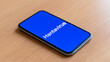 © A2Z AI  - Smartphone Display With Illness Name Text Resting on a Neutral Wooden Desk, Illustrating a Global Health Information Concept
