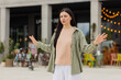 © Andrii Iemelianenko - Young woman calming down walking in city street with deep breath after stressful work. Girl tourist meditating outdoors and calming mind with breathing practice after tension near busy office center.