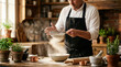 © imammudzakir - Chef sifting flour into bowl in rustic kitchen, preparing dough for baking