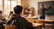 © Olga - Attentive Student in Classroom with Teacher Writing on Chalkboard, Education Concept