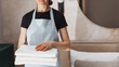 © brizmaker - Maid holds fresh folded towels in hotel room for guests enjoying their stay