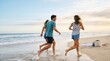 © MT - Three young adult friends running along the beach at sunset, carefree lifestyle, active leisure, summer vacation, friendship concept