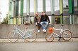© Westend61 - Happy couple with bicycles sitting on a wall