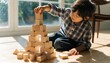 © Mohitosh - Curious young child building a tall wooden block tower on sunlit floor, creative play at home, Montessori inspired learning, fine motor skills, problem solving, childhood development