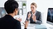 © TheseusStock - Authoritative manager interrupting an employee in a tense office meeting