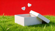 © bestty - White gift box with hearts on grass