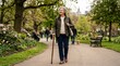 © Konstantin - Active senior woman walking with a cane in a lush green park. Elderly female strolling on a pathway in spring garden