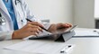 © Liew - Doctor using a tablet computer for medical documentation and record keeping in a clinical setting.