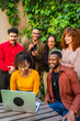 © unai - Diverse people participating in group therapy outdoors using laptop