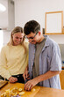 © Adrian Rodd/Stocksy - A happy couple shares a laugh while slicing fresh vegetables together