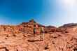 © zhukovvvlad - A mother and child on a hike. A boy with a map and a backpack walks next to his mother. Family trekking. Timna National Park. The child is actively spending time.