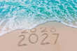 © MAITREE - Message Year 2026 replaced by 2027 text written on beach sand background. Good bye 2026 - 2027 happy New Year coming concept.  top view.