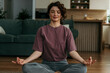 © La Famiglia - Woman meditating in lotus position practicing mindfulness at home