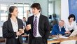 © JackF - Smiling man and woman colleagues spending free time at coffee break in modern office