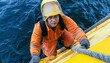 © jannik27s - A man in an orange safety suit climbing onto a yellow rescue boat in the middle of the ocean