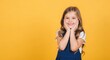 © MstKhadiza - Young girl with blonde hair smiling and resting her chin on her hands against a bright yellow background