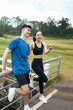 © PaeGAG - Young couple resting pointing looking away after running