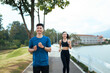 © PaeGAG - Young Asian couple jogging smiling enjoying outdoor workout