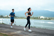 © PaeGAG - Asian couple jogging together along lake for healthy lifestyle
