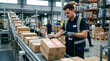 © Matos - Warehouse worker scanning packages on a conveyor belt using a handheld barcode scanner for logistics and inventory management