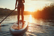 © Евгения Гаращенко - Person standing on a stand-up paddleboard viewed from the back during a peaceful summer adventure