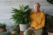 © Iryna - Mature man posing beside large potted plant indoors