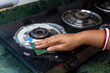 © DIPIKA - close up of woman hand washes using a green sponge with foam cleaning stainless steel gas stove in the kitchen. ensuring hygienic and cleaning maintenance concept.