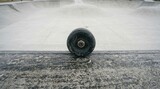 Skateboarder wheels on concrete, black skateboard on wooden ramp