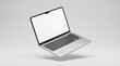 © Ievgeniia - Open laptop computer floating at an angle with blank white screen and visible keyboard and touchpad, studio lighting, minimal design, no text