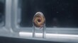 © Cosmic - Transparent cosmic egg containing a swirling golden galaxy displayed on a metal stand