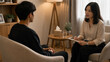 © Teeradej - Asian teenager sitting across from a counselor in a warm, softly lit therapy room. Youth mental health support concept.