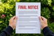 © novi - Man Holding a Final Notice Document with Red Text Outdoors