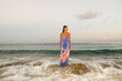© Studio KME/Stocksy - Woman Standing on Rock in Ocean Waves