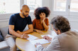 © BONNINSTUDIO/Stocksy - Couple consulting financial advisor discussing important documents