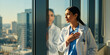 © Vadym - Female doctor stands by window looking out at city skyline. Touches chest with hand. Healthcare professional contemplates medical decision. Doctor reflects on patient care. Woman in clinic thinks.