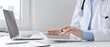 © rogerphoto - Female doctor wearing lab coat and stethoscope using digital tablet with laptop and medical records on desk in medical office, showcasing modern healthcare technology. Medicine concept