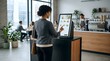 © Ethan - Professional woman using self-service kiosk to order food in a modern cafe