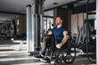 © Serhii - Man with disability, athlete doing rehabilitation exercises with cable machine in gym
