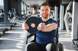 © Serhii - Man with disability lifting weights in a wheelchair at the gym