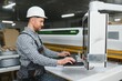 © Serhii - Skilled worker operating cnc machine in furniture factory
