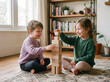 © C&A - Young brother and sister building a tower with wooden blocks while playing together at home to develop creativity, teamwork and early learning skills