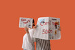 © Pixel-Shot - Two people holding newspapers with 'fake news' and 'coming soon' headlines on an orange background, Disinformation and anticipation concepts are conveyed by two people holding newspapers